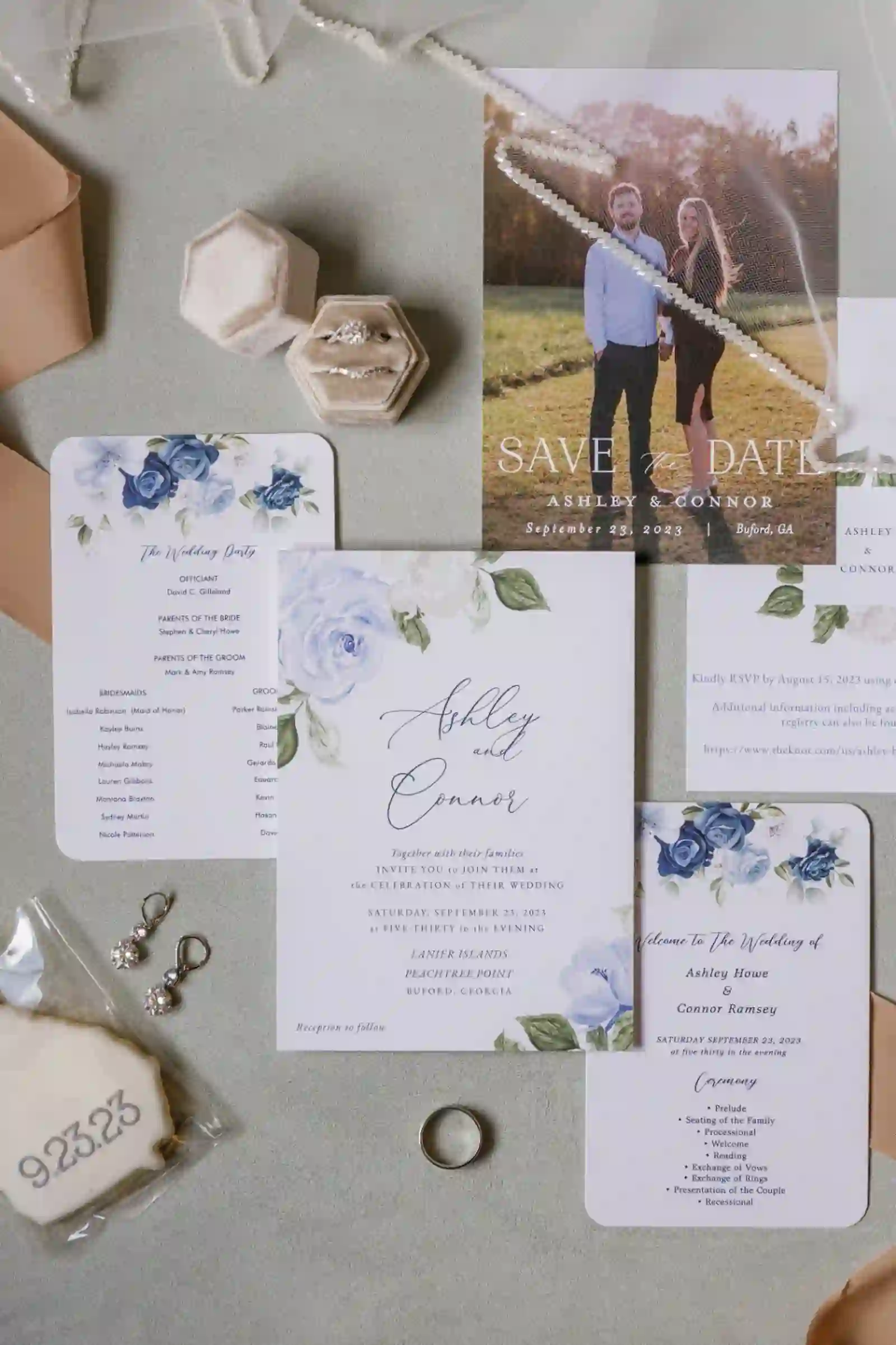 Wedding invitation suite with rings, earrings, and ribbon flatlay