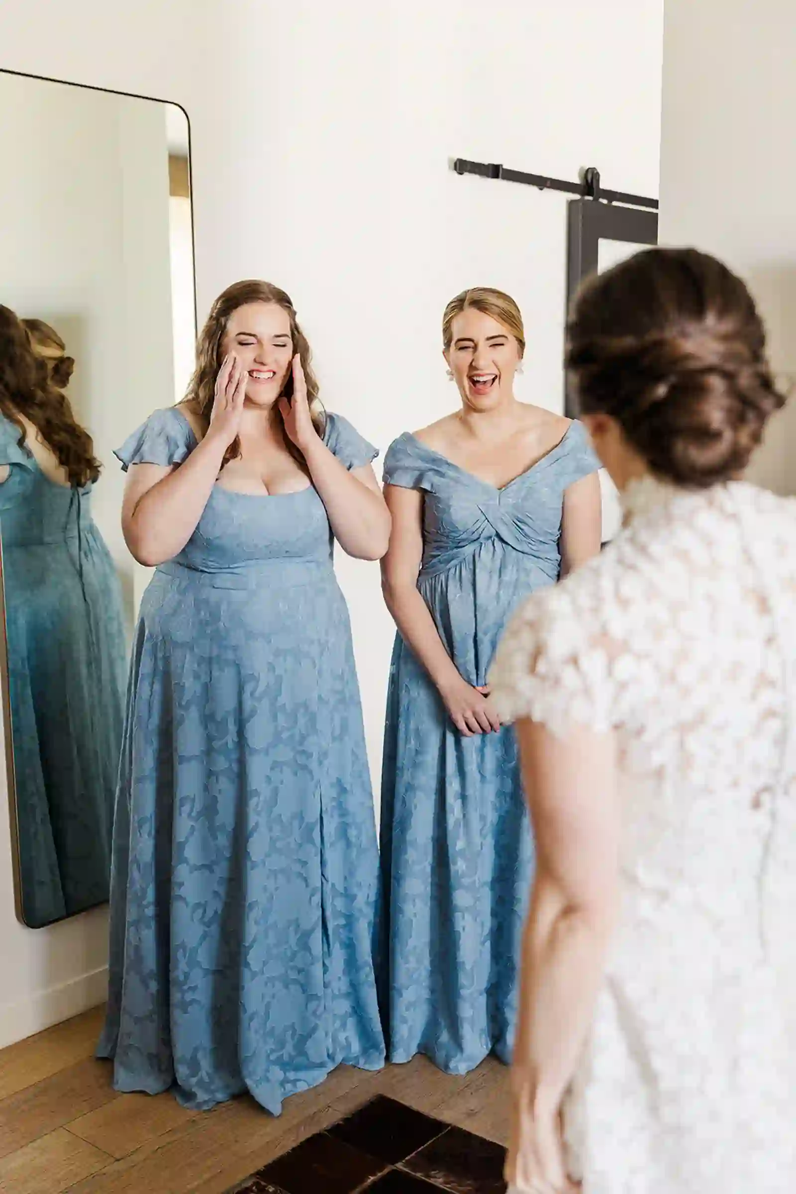 Bridesmaids reacting emotionally as they see the bride in her gown