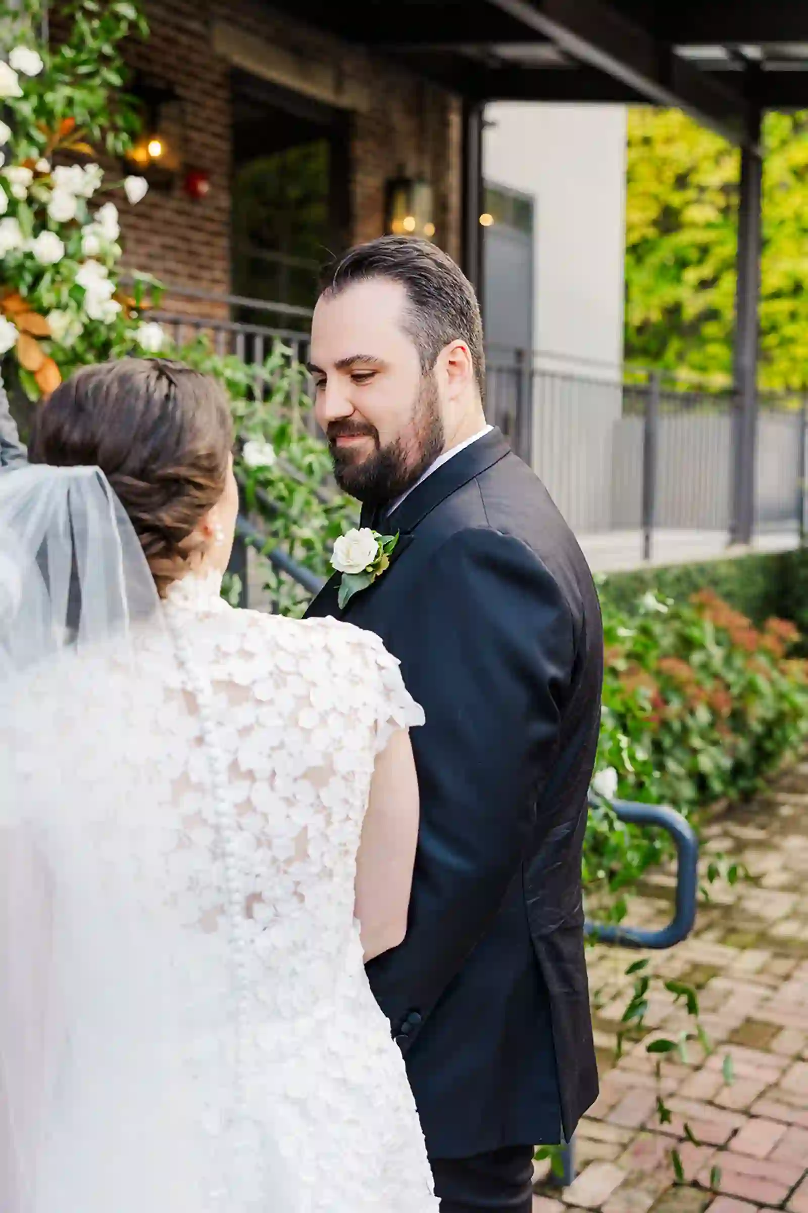 Tender first-look moment between the bride and groom outside the venue