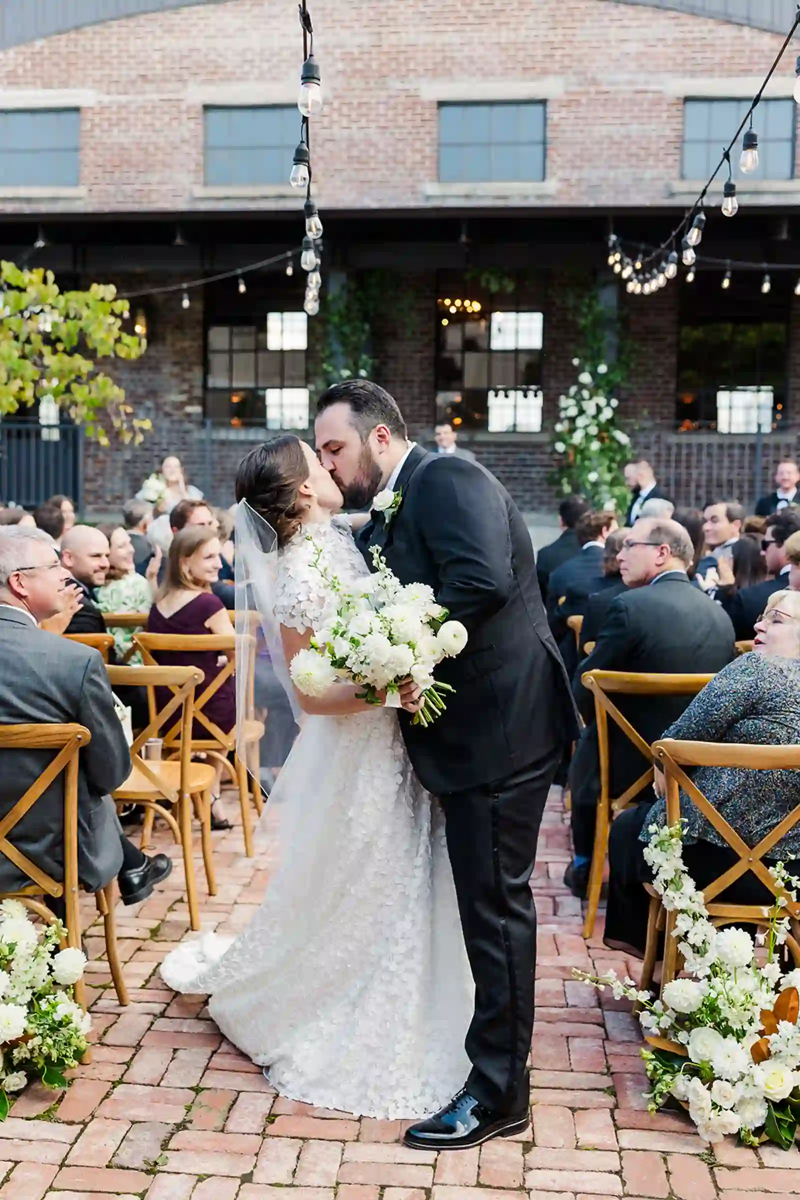 Newlyweds sharing their first kiss as a married couple in the aisle