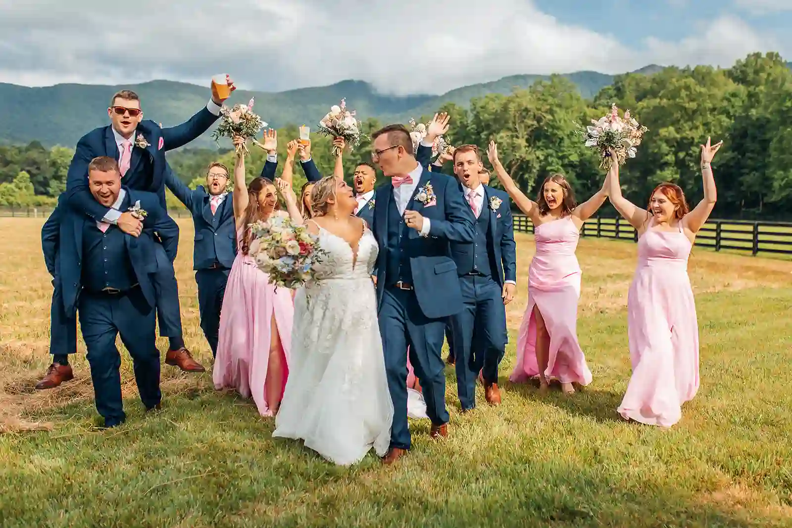 Joyful wedding party portrait with bouquets raised in celebration