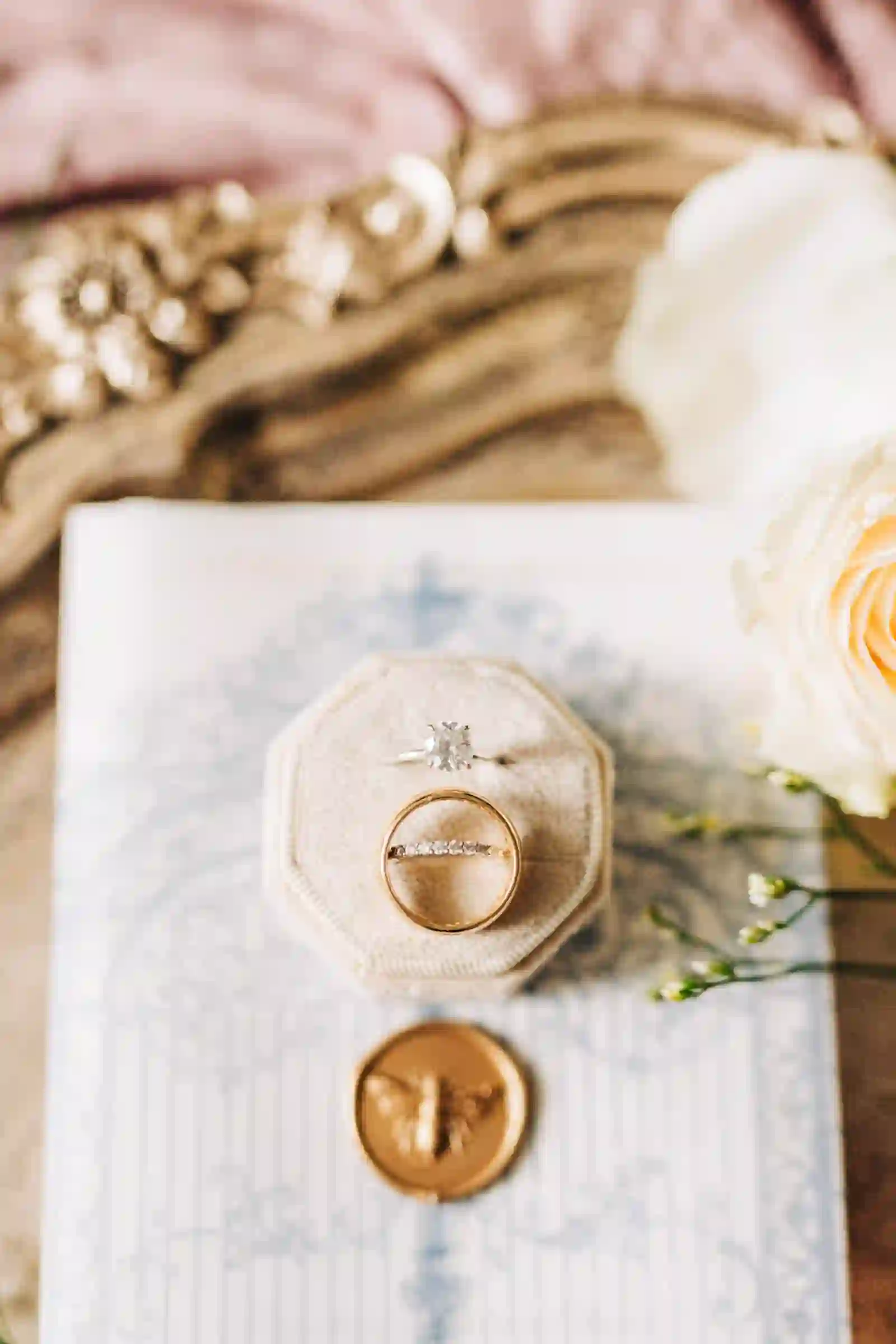 Wedding rings styled over invitation paper