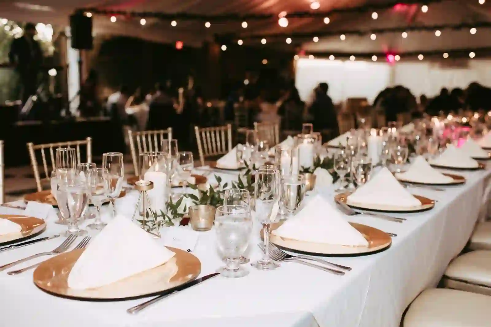 Candlelit reception tablescape with gold chargers