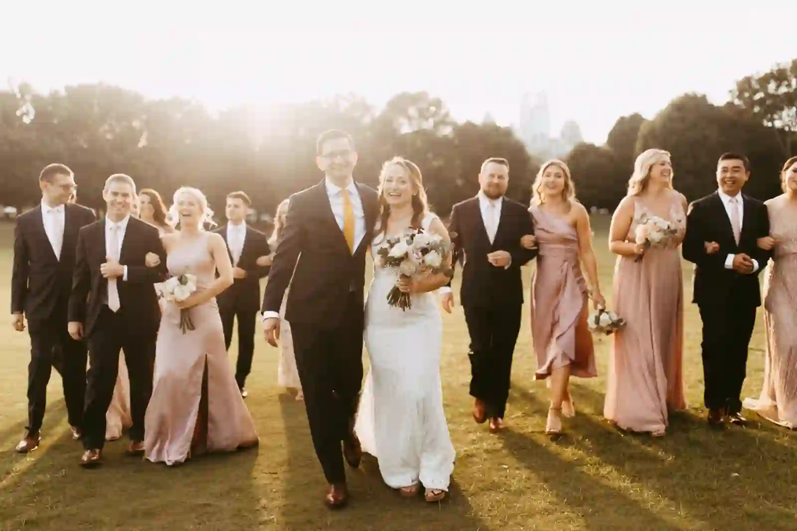 Wedding party walking together through Piedmont Park at sunset