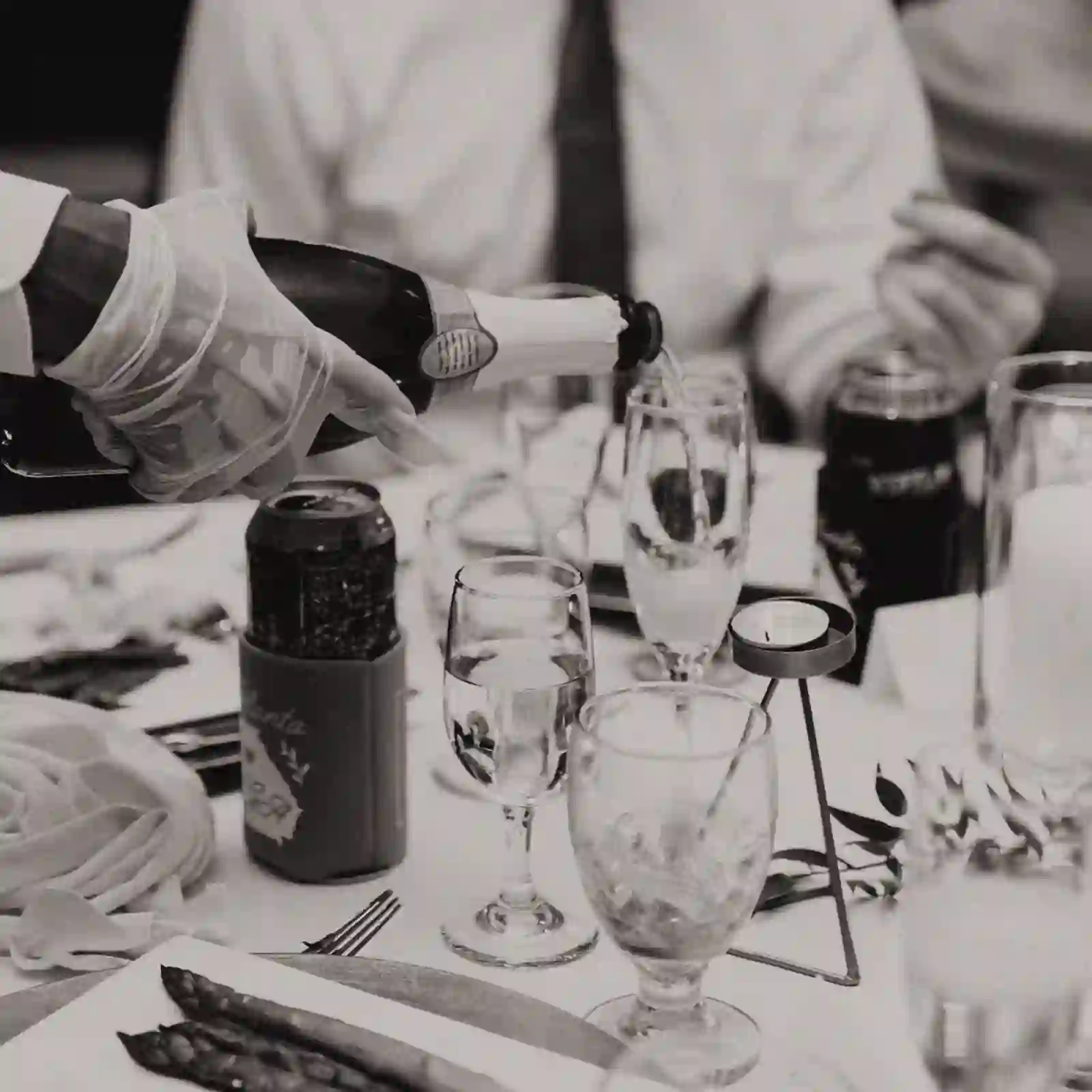 Black and white moment of champagne being poured at the reception