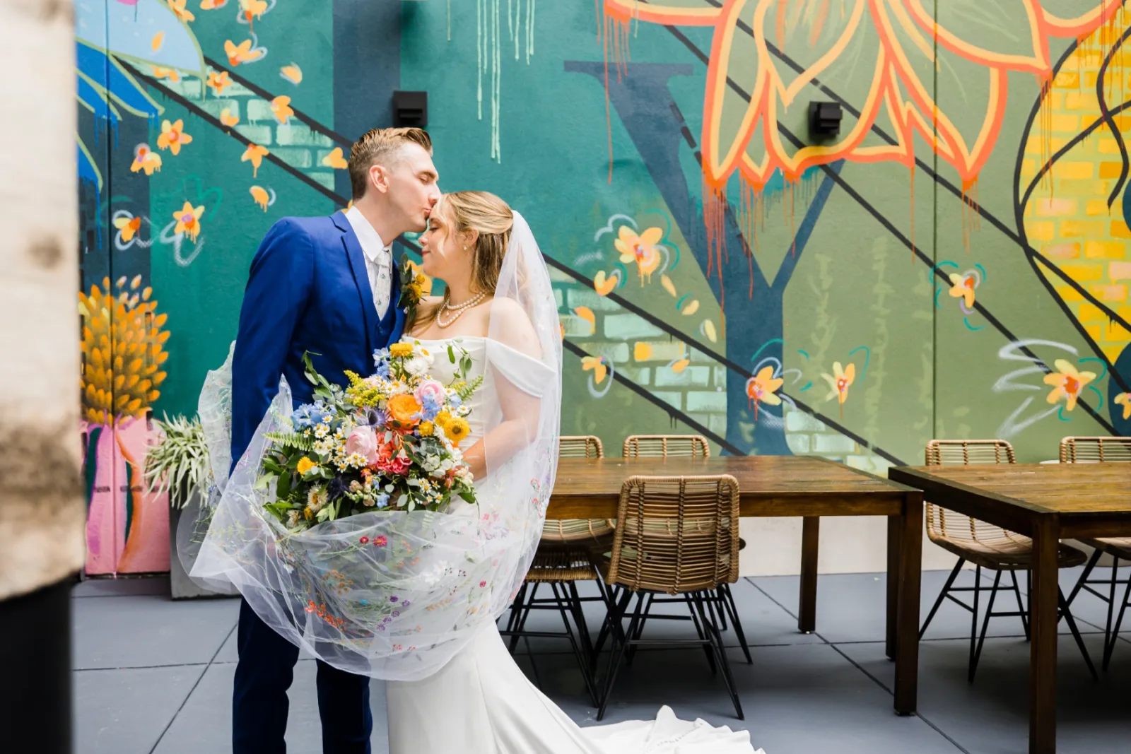 Forehead kiss with wildflower bouquet