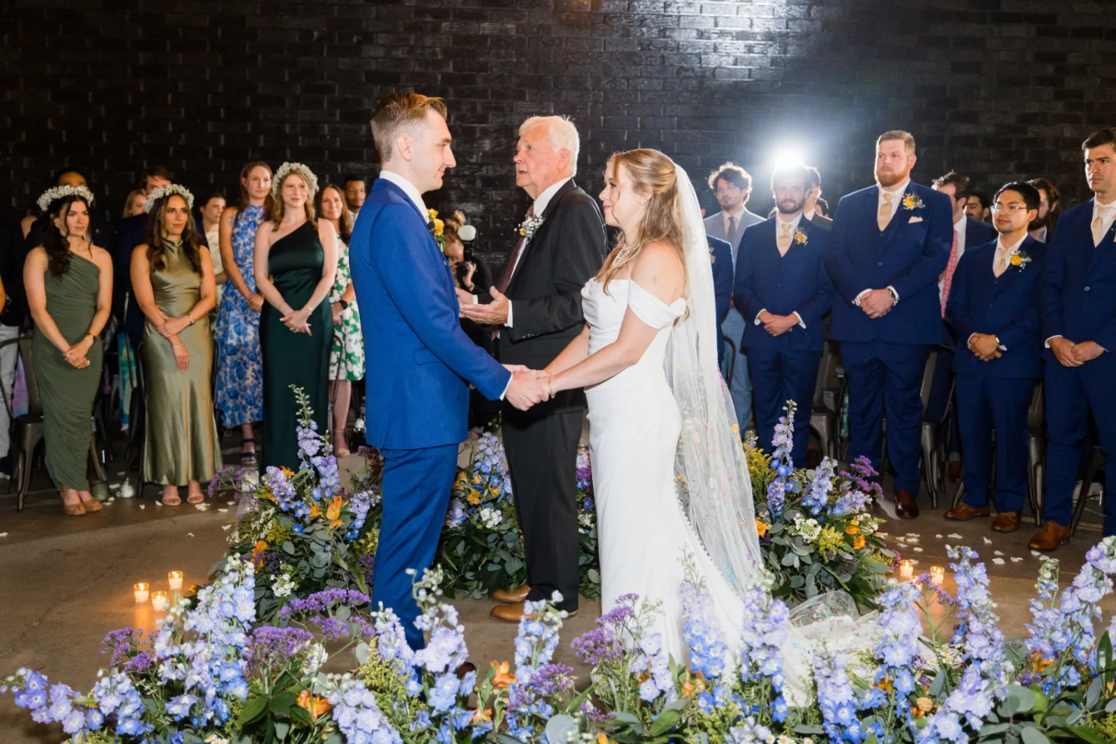 Wide ceremony moment with guests surrounding the couple