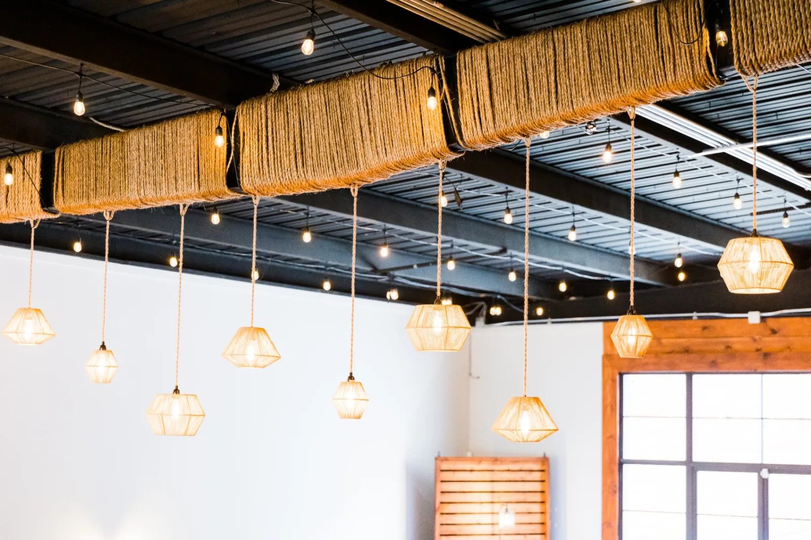Rope-wrapped beams and rattan pendants overhead