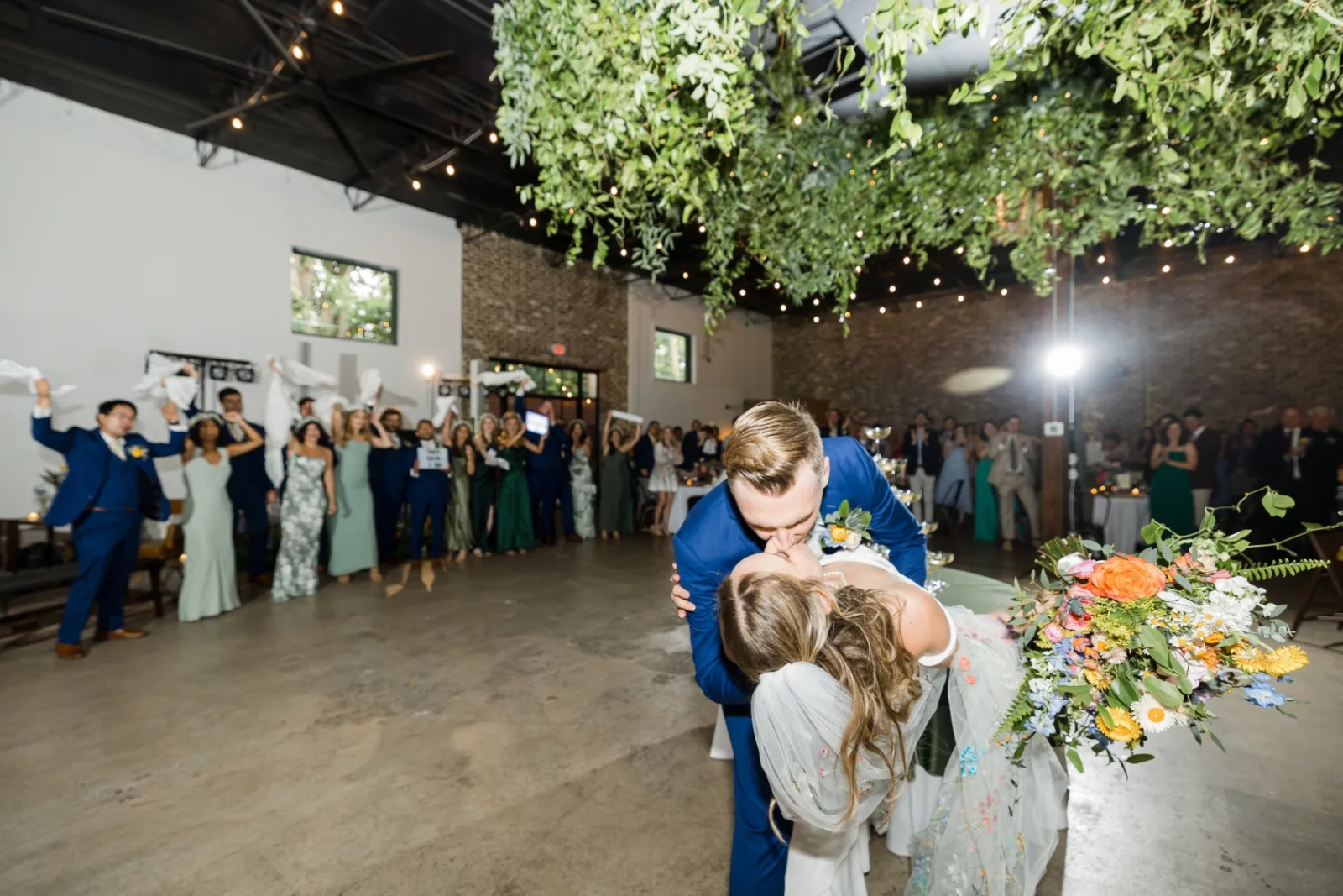 Dip kiss under hanging greenery installation